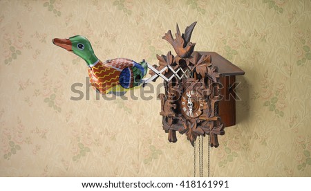 Tin toy duck coming out of Cuckoo Clock against flowery wallpaper