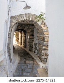 Tinos island Greece. Cycladic architecture at Kardiani village, arched stonewall covers narrow cobblestone alley, whitewashed wall. Vertical - Shutterstock ID 2275414821