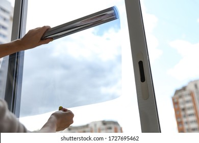 Tinted Glass In The House. Window Dimming By Dark Film. Hands Apply Tint Film To The Window. Tint Film On Sky Background. Sky View Through Tinted Glass