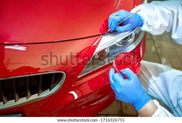 Tinting defects\
of a red car paint on the\
service
