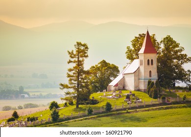 Tiny beautiful small church in Slovakia village with mountain on background