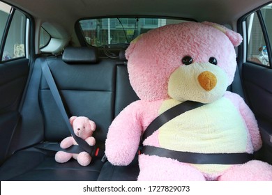 Tiny And Bigger Teddy Bear With Safety Belt In The Backseat Of The Car, Safety Drive And Child Care On The Road Concept.