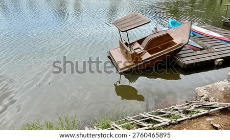 A tiny boat docked at the edge of the lake. Perfect for photos or a romantic tour for two.