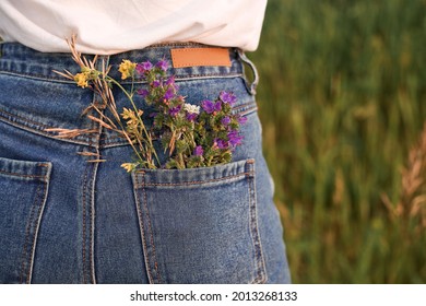 A Tiny Bouquet Of Field Flowers In A Back Pocket Of Woman's Jeans