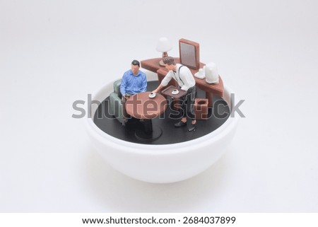 A tiny cafe scene inside a white bowl features a miniature figures: