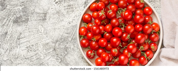 Tiny cherry tomatoes (ciliegini, pachino, cocktail). group of cherry tomatoes on a gray concrete background. ripe and juicy cherry tomatoes/