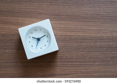 tiny clock on wooden background