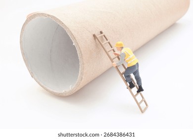 A tiny construction worker figurine with a yellow vest and helmet