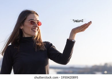 tiny drone landing on young woman's palm