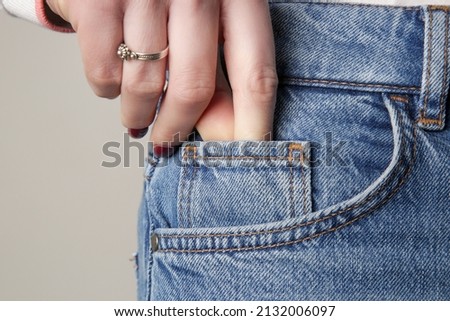 Tiny front pocket on denim pants, close up.	