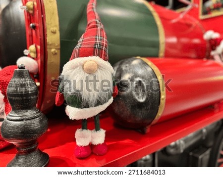 A tiny gnome doll dressed in Scottish style stands as a Christmas shop decoration.