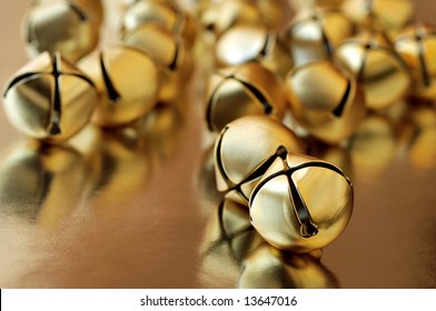 tiny gold jingle bells reflecting on metallic gold paper.  Macro with extremely shallow dof.  Selective focus on closest bell. - Powered by Shutterstock