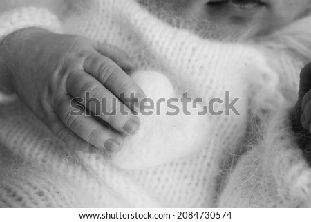 Similar – Baby schläft auf einer Decke mit der Hand ihrer Mutter.