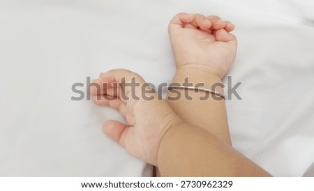 A baby’s tiny hand resting gently against a clean white background, symbolizing purity, innocence, and new beginnings.