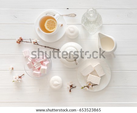 tiny hands holding sweets for tea ceremony in pastel pink and white colors, porcelain, topview