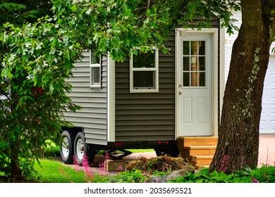 Tiny Home On Wheels Framed By Trees And Flowers