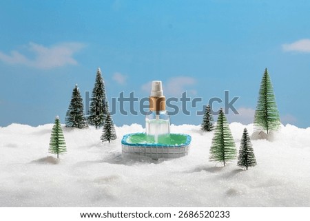 A tiny, inviting pool rests in a blanket of snow, framed by miniature festive pine trees. The detail of a plastic spray bottle floating within the pool adds a modern, almost surreal touch