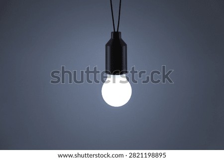 A tiny light bulb keychain gives off warm white light