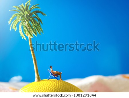 tiny miniature man sitting at beach chair looking at sea