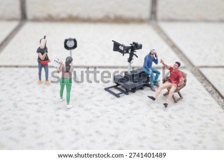 Tiny model filmmakers collaborate using cameras lights and equipment