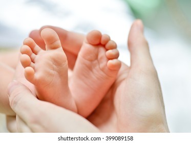 tiny newborn's foot in the mother hands in soft focus - Shutterstock ID 399089158