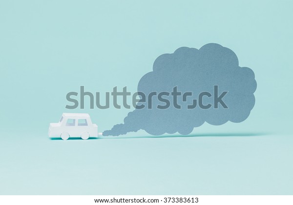 Tiny paper car\
and smoke on blue\
background.