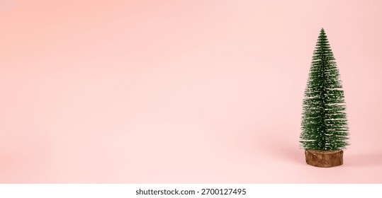 tiny pine on peach background, small evergreen decoration with empty space for greetings or products, tiny evergreen ornament on peachcolored background with room for messages