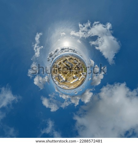 tiny planet in sky with clouds overlooking skyscrapers in new modern residential complex with high-rise buildings in town.  Transformation of spherical 360 panorama in abstract aerial view.
