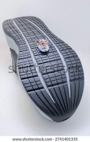 Tiny rafting team rows vigorously across textured sneaker surface