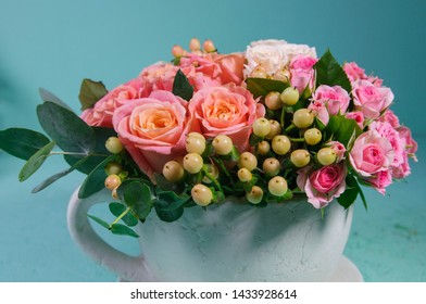 Tiny roses in a tea cup with small angels
