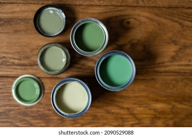 Tiny Sample Paint Cans During House Renovation, Process Of Choosing Paint For The Walls, Different Green Colors On Wooden Floor
