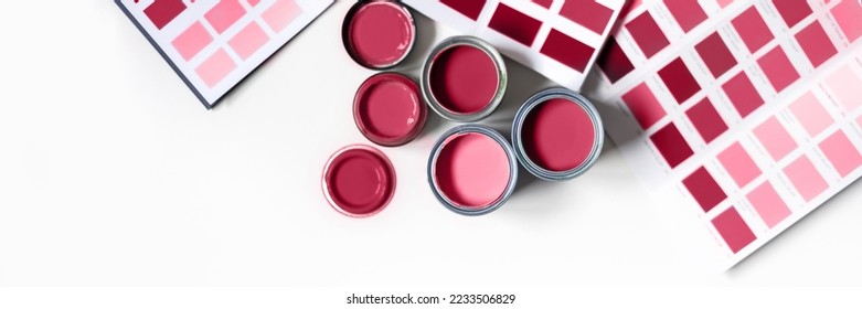 Tiny sample paint cans during house renovation, process of choosing paint for the walls, different red colors, color charts on background. Viva Magenta, color of the year 2023 - Shutterstock ID 2233506829