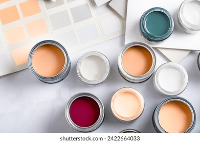 Tiny sample paint cans during house renovation, process of choosing paint for the walls, Peach Fuzz color of the year 2024, color charts on background - Powered by Shutterstock