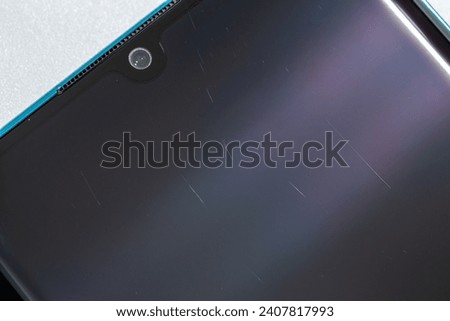 tiny scratches on clean used contemporary smartphone screen surface, macro photo.