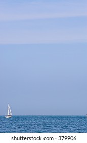 A tiny ship sailing across the blue sea