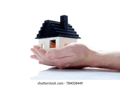 Tiny Toy Bricks House In Hand White Background