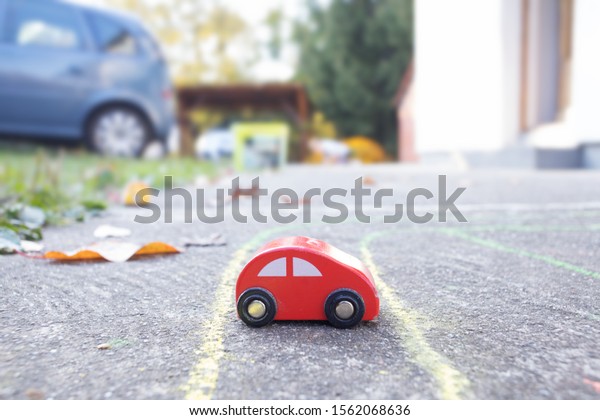 tiny toy car in\
garden next to real\
vehicle
