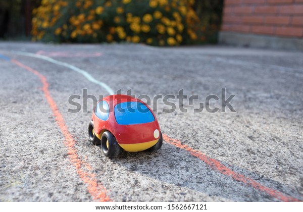 tiny toy red car on the\
playground