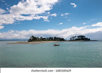 Tiny Tropical Island In Calm Warm Ocean With Small Boat