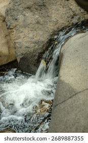A tiny waterfall hidden among rocks — soft, pure, and endlessly soothing.