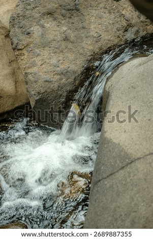 A tiny waterfall hidden among rocks — soft, pure, and endlessly soothing.