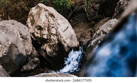 Tiny waterfall hidden between giant rocks, where motion and stillness meet in harmony. 
