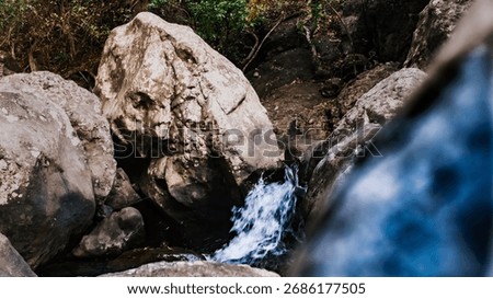 Tiny waterfall hidden between giant rocks, where motion and stillness meet in harmony. 