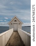 Tiny white boat shed by the sea
