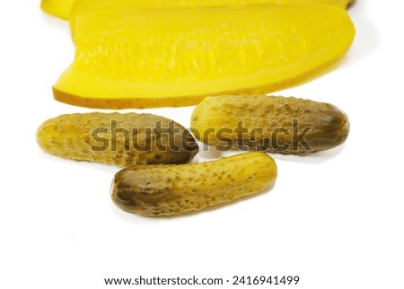 Tiny Whole Pickles in Front of Large Sandwich Sliced Pickles