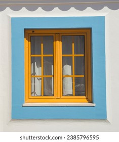 Tiny window painted with vivid colors at Vila Nova de Milfontes house. Little picturesque town on the Alentejo coast, Portugal