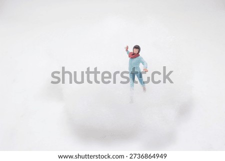 Tiny winter character posed inside fluffy cloudlike artificial snow