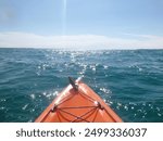 Tip of kayak in the water on a sunny day.