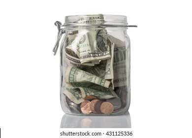 A tip or savings jar filled with American coins and bills.