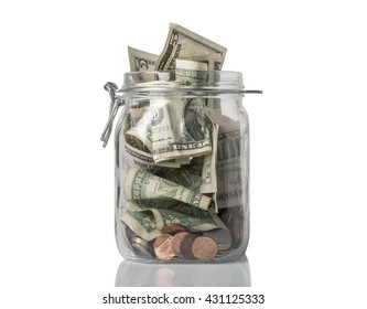 A tip or savings jar filled over the top with American coins and bills. - Powered by Shutterstock